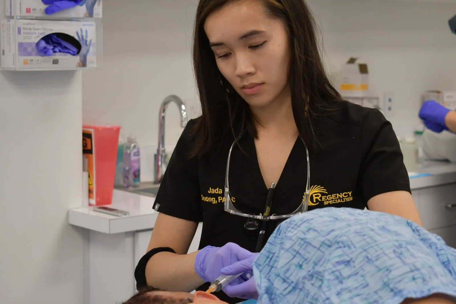 Regency Specialties team member examining a patient's skin in a clinical setting